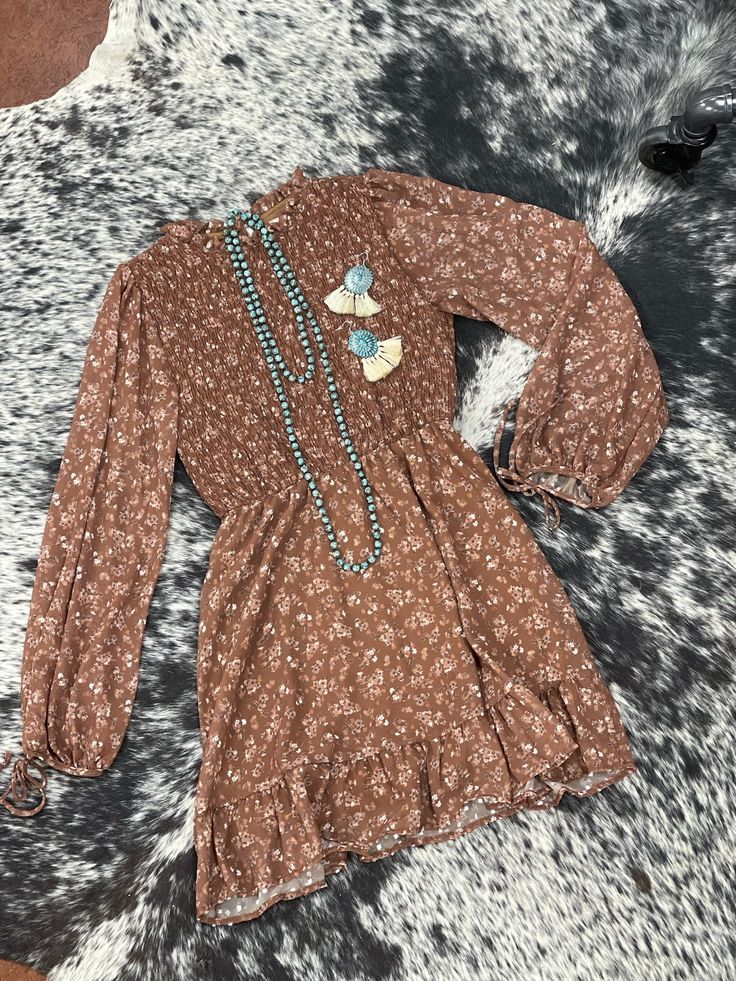 This beautiful long sleeve floral print smocked bodice mini dress is one we know you will love in stunning brown tones! This dress is perfect for any occasion with great details of ties and sheer sleeves! Brown Bohemian Dress With Smocked Bodice, Brown Long Sleeve Dress For Fall, Casual Brown Long Sleeve Dress, Spring Brown Dress With Smocked Bodice, Bohemian Brown Mini Dress For Fall, Bohemian Long Sleeve Mini Dress With Smocked Bodice, Flowy Long Sleeve Mini Dress With Ditsy Floral Print, Chic Brown Long Sleeve Dress For Spring, Bohemian Mini Dress With Smocked Bodice And Long Sleeves