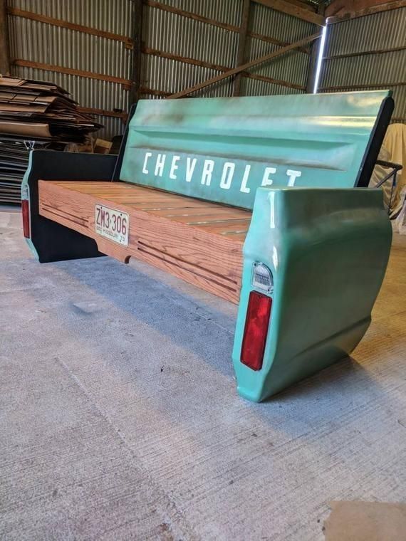 the back end of a pickup truck in a garage with wood planks on the floor