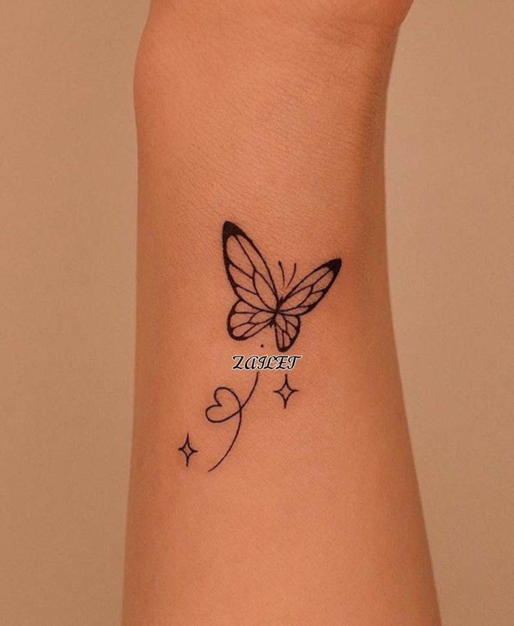 a small butterfly tattoo on the wrist