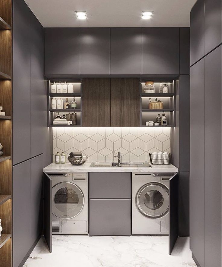 a washer and dryer in a small room with shelves on the wall behind them