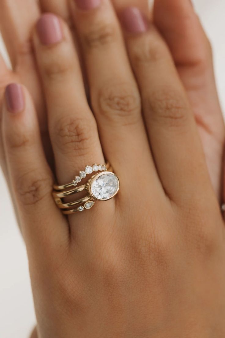 a woman's hand with two rings on it and a diamond ring in the middle