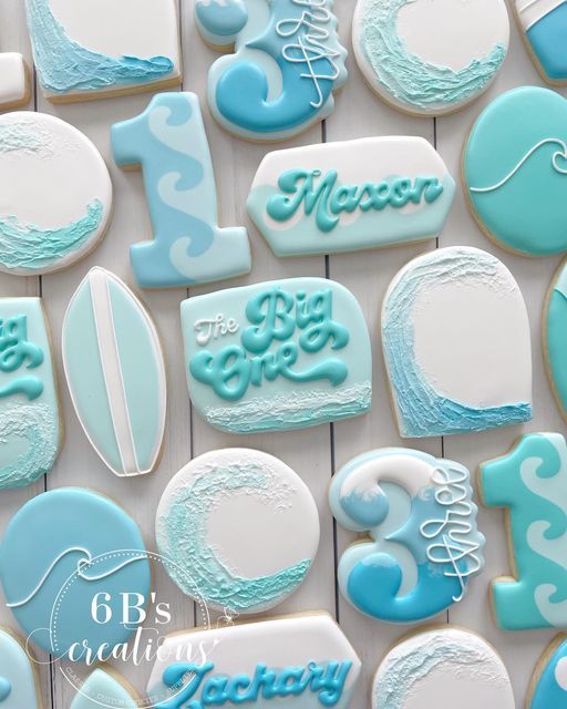 cookies decorated with blue and white icing are displayed