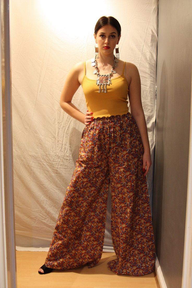 A beautiful pair of handmade kalamkari palazzo pants made from Indian cotton. Kalamkari is an art form from the Indian states of Andhra Pradesh and Telangana. The word comes from the persian "qalam" meaning pen. Traditionally this art was hand drawn directly on the fabric by artisans. The fabric used in these trousers is a machine made version.  They have an elasticated waist and will fit UK sizes 4-12. Length: 46 inches Traditional Straight Pants With Printed Motifs, Traditional Pants With Printed Motifs For Festivals, Yellow Bohemian Cotton Pants, Yellow Cotton Bohemian Pants, Traditional Cotton Bottoms With Printed Motifs, Traditional Block Print Cotton Pants, Traditional Cotton Block Print Pants, Traditional Cotton Harem Pants For Navratri, Bollywood Style Cotton Bottoms For Navratri