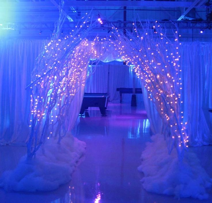 an archway decorated with lights and white drapes