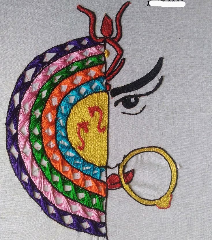 an embroidered piece of cloth with a woman's face on it