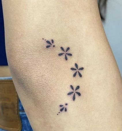 a woman's foot with small black flowers on her left side and the word love written in it