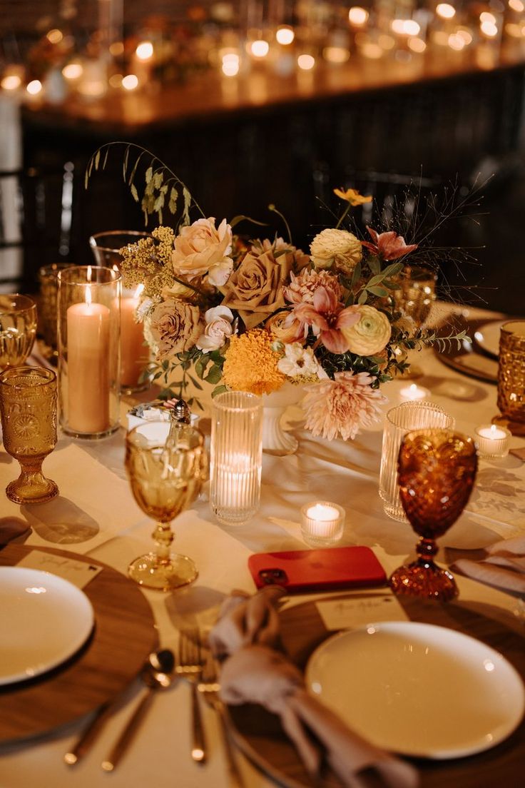 the table is set with candles, flowers and napkins for an elegant wedding reception