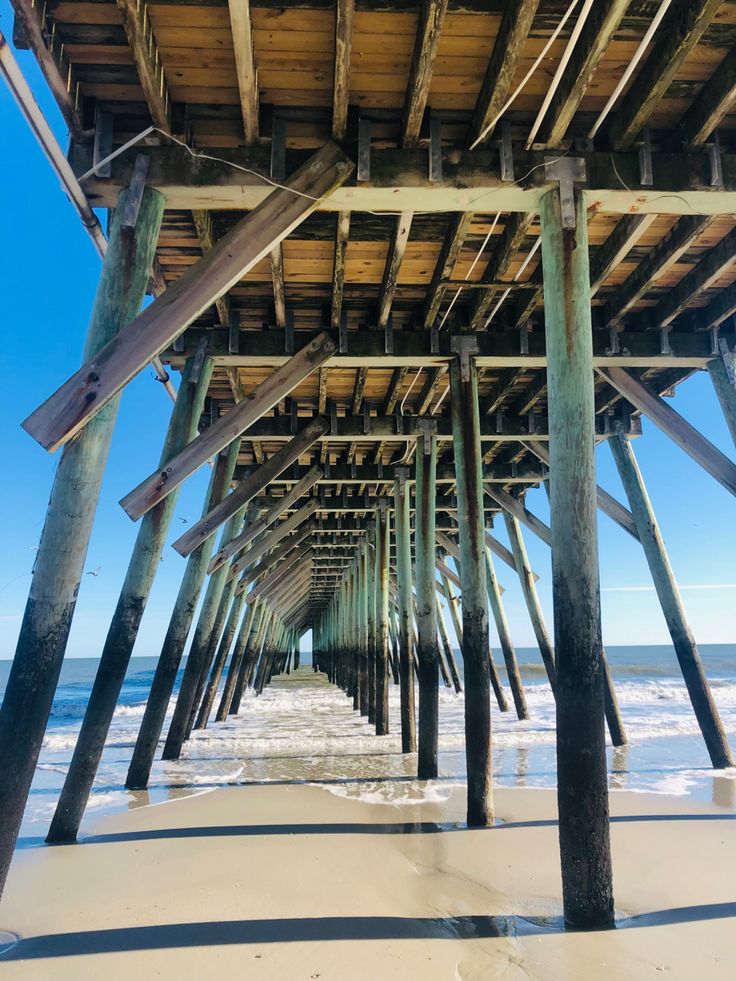 the underside of a wooden pier at the beach