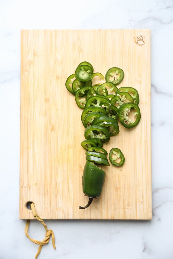 green peppers are cut up on a cutting board