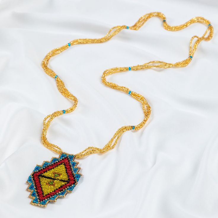 Trendy and tribal-inspired, the Mayan Pyramid Beaded Pendant Necklace makes a bold statement. Perfect for pairing with whites or denim for a great boho look. Made by women artisans of La Casa in Guatemala. Since 2000, La Casa Cotzal has designed a range of Guatemalan handcrafted pieces produced by artisan communities throughout the country. Mayan women traditionally have been backstrap loom weavers, but increasingly they are learning to use pedal looms as well. In traditional Guatemalan weaving, the two main specialized techniques are ikat and supplementary weft brocade. Artisans at La Casa are versed in both weaving techniques as well as in intricate bead work. The work provided by La Casa is vital to the women's families and communities. Glass beads & cotton thread Pendant: 3.25" H x 2" Bohemian Beaded Long Necklace For Festivals, Bohemian Long Beaded Necklaces For Festivals, Bohemian Long Beaded Necklace For Festivals, Handmade Bohemian Beaded Necklaces For Festivals, Multicolor Bohemian Jewelry With Gold Beads, Artisan Beaded Jewelry For Festivals, Artisan Beaded Jewelry For Festival, Bohemian Beaded Jewelry For Festivals, Artisan Yellow Beaded Necklaces For Festivals