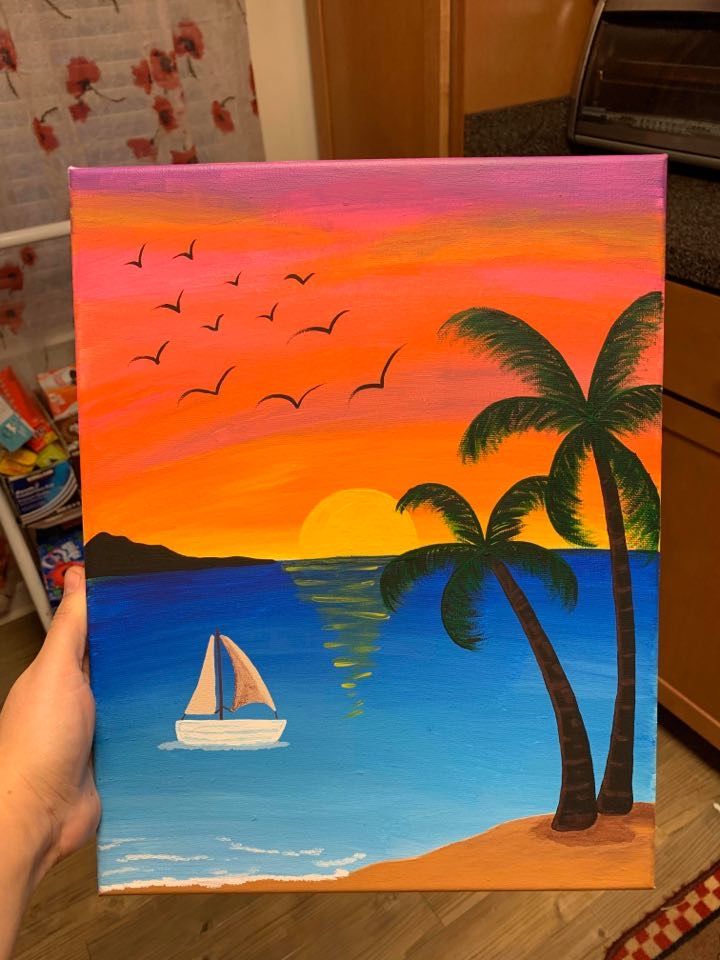 a person holding up a painting with palm trees and boats in the water at sunset