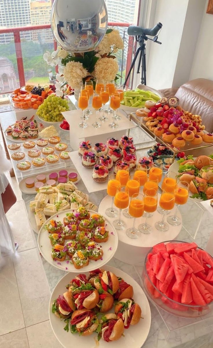 a table filled with lots of food and drinks on top of white plates next to each other