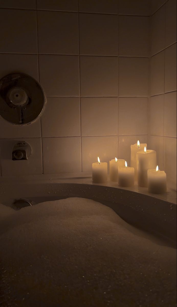 lit candles sit in the middle of a bathtub