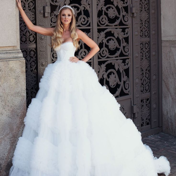 a woman in a wedding dress posing for the camera