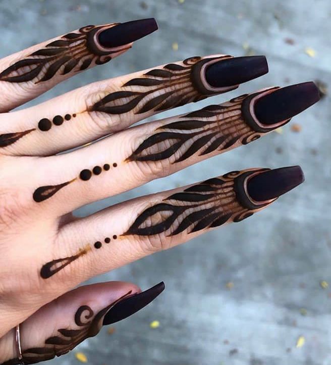 a woman's hand with black and brown designs on it