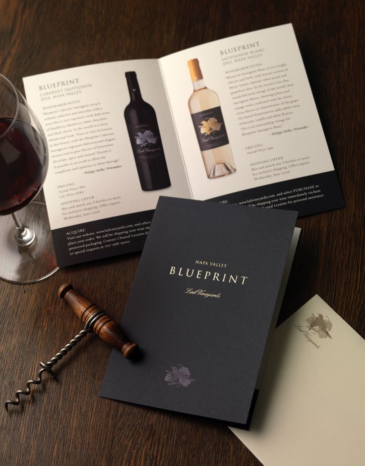 an open wine bottle next to a glass of wine on top of a wooden table