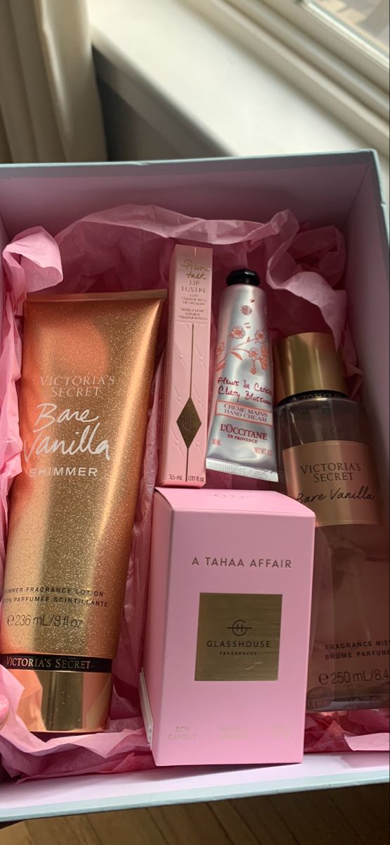 an open pink box containing three different types of beauty products and a bottle of lotion