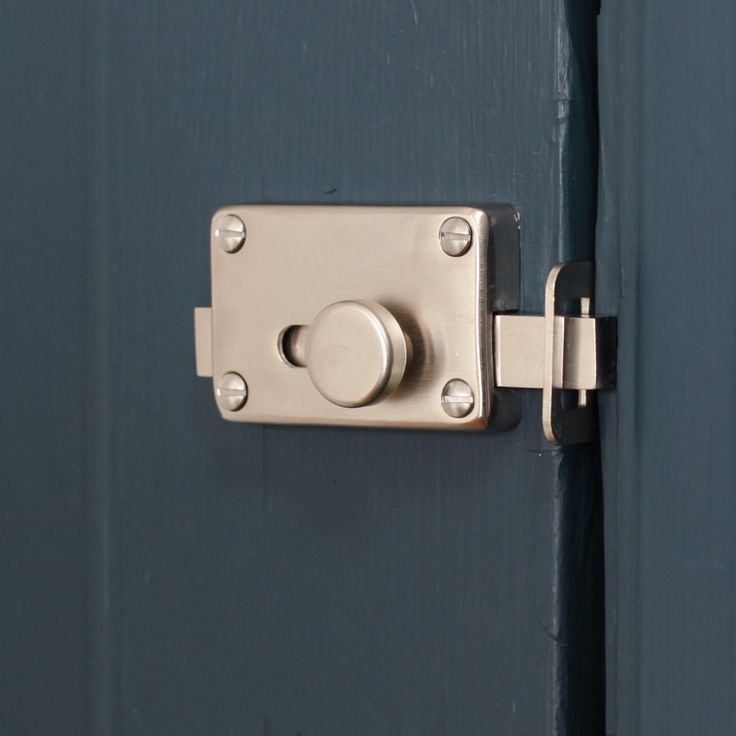 an open door with a metal handle and knob on the front side, showing that it is not in use