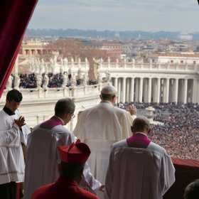 people in white robes and red hats standing at the alter looking out over a large crowd