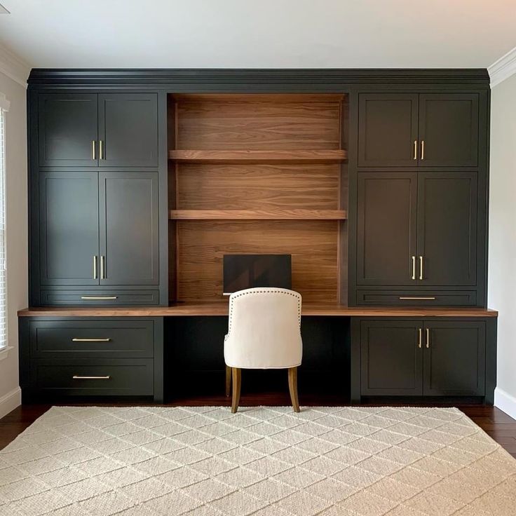 an office with black cabinets and a white chair