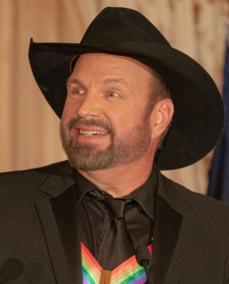 a man wearing a black hat and tie