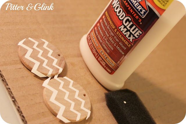 a bottle of wood glue next to two wooden buttons