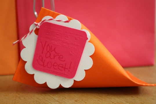 an origami triangle shaped gift bag with a note attached to the tag that says you are sweet