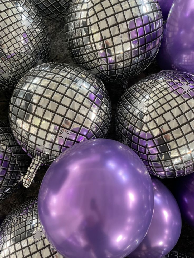 purple and silver balloons are piled on top of each other