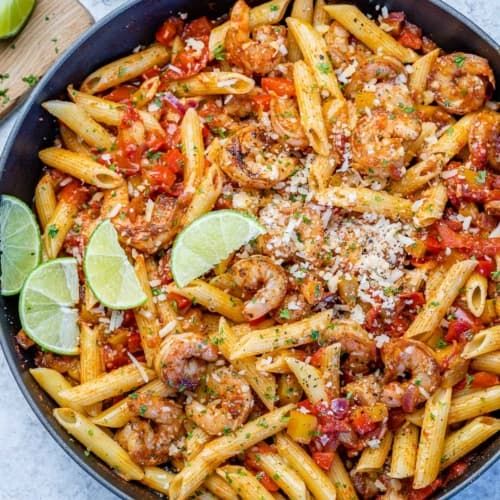 a skillet filled with pasta, meat and sauce