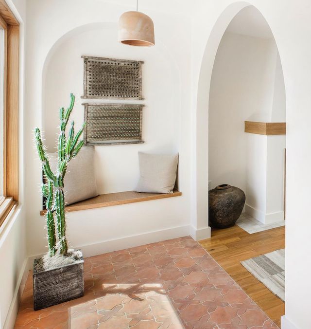 a cactus in a pot sitting on a window sill next to a door way