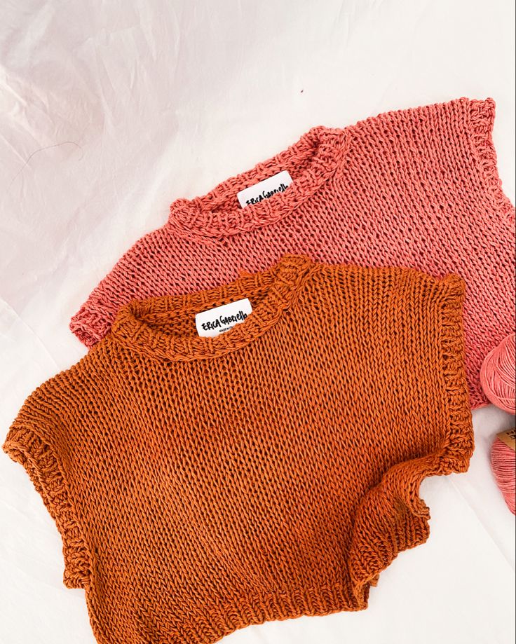 two knitted sweaters sitting next to each other on a white surface with the words noise written above them