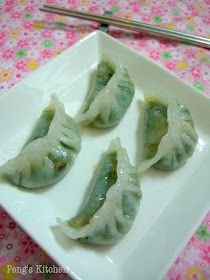 four dumplings are sitting on a white plate with green sauce and silver tongs