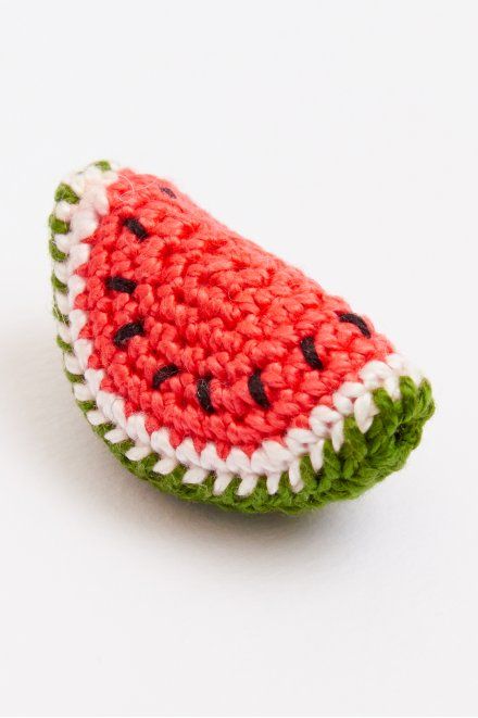 a crocheted watermelon ornament sitting on top of a white surface