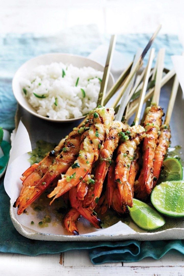 shrimp skewers with lime wedges and rice