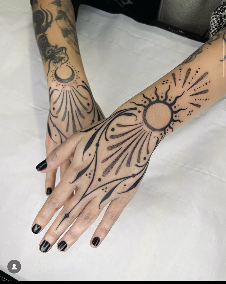 a woman's arm with tattoos on it and her hand in the shape of a sun