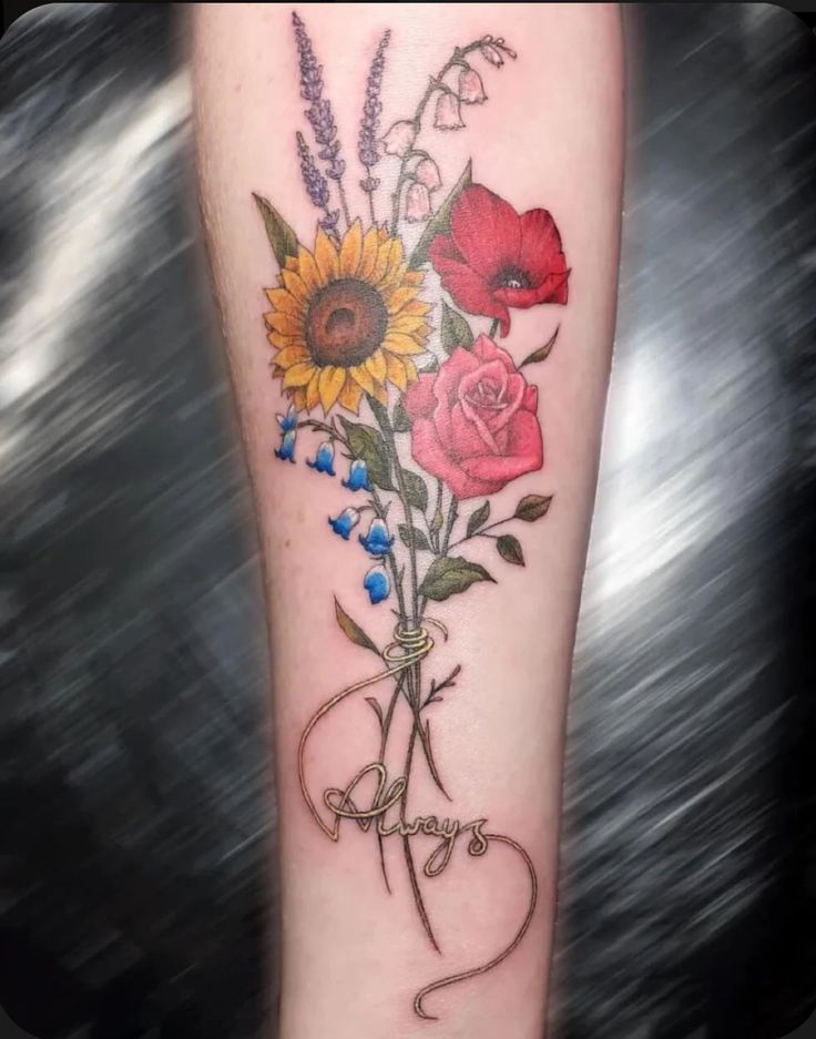 a woman's leg with flowers on it and the word happy written in cursive writing