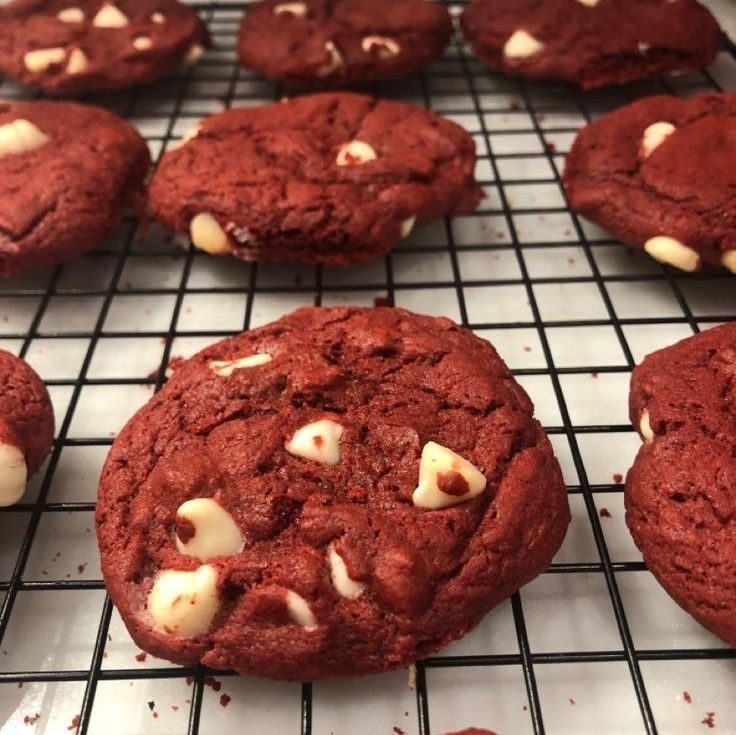 cookies with white chocolate chips are cooling on a rack