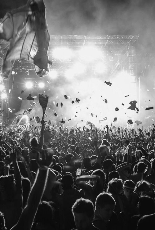 a large group of people at a concert with confetti thrown in the air