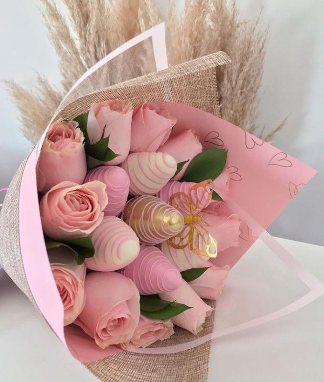 a bouquet of pink roses is wrapped in paper