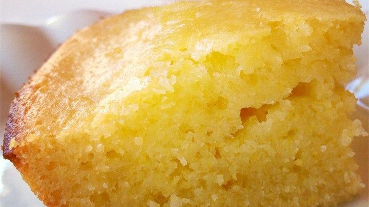 a piece of yellow cake sitting on top of a white plate