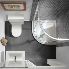 an overhead view of a modern bathroom with white fixtures and gray tile walls, including a toilet