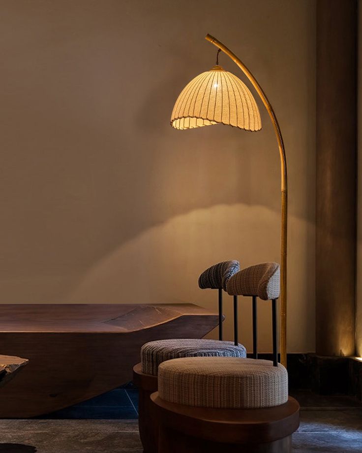 a lamp that is sitting on top of a table next to a chair and ottoman