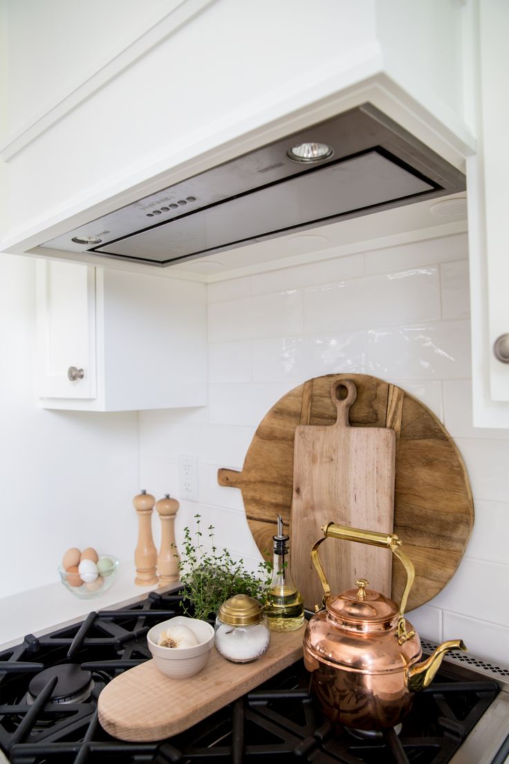 a kitchen stove with a cutting board on the burner and other cooking utensils