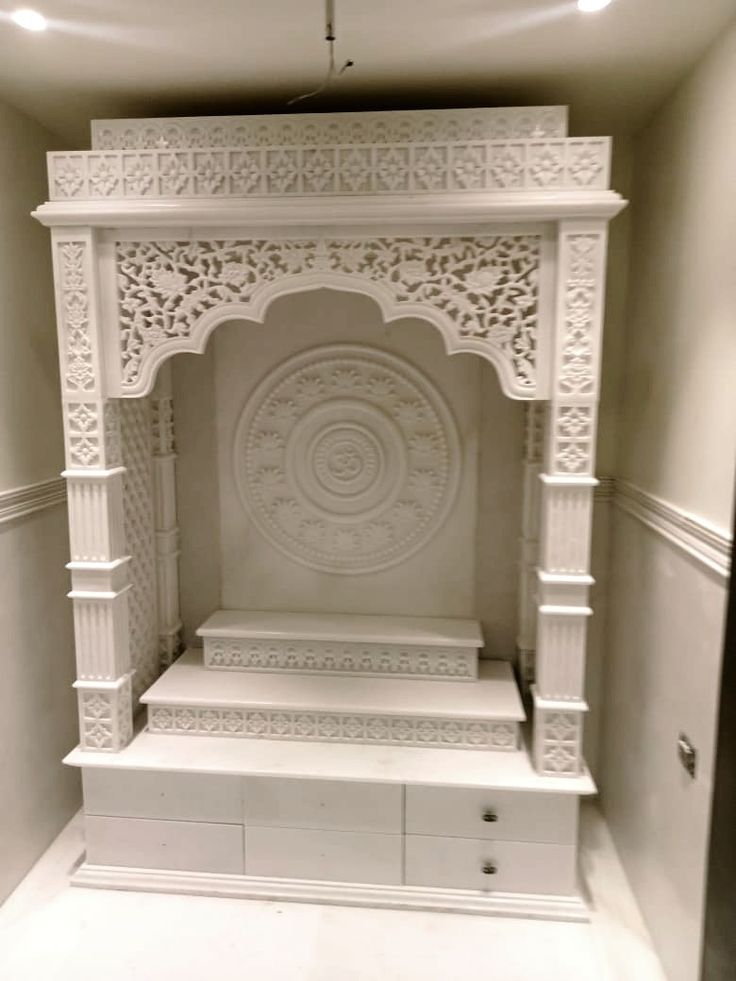 an ornate white fireplace in the corner of a room