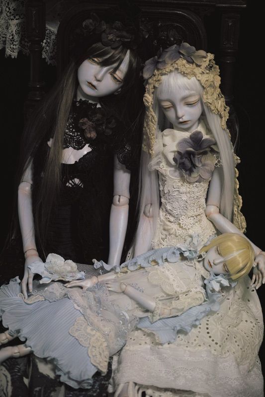 two dolls dressed in white sitting next to each other