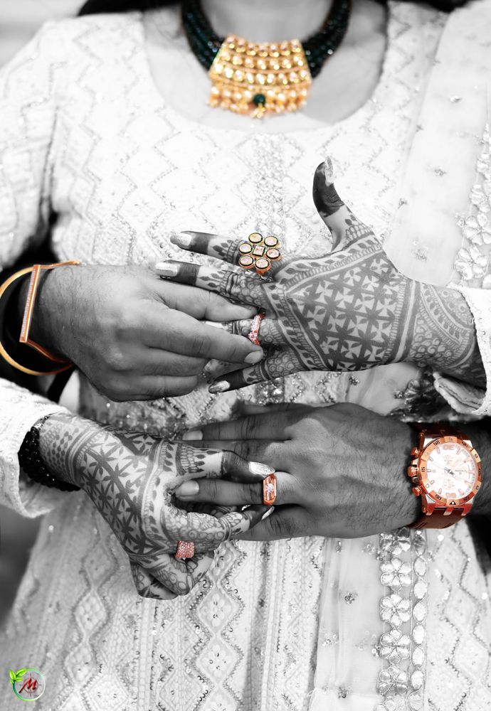 two people with their hands covered in hendi and bracelets, one holding the other's hand