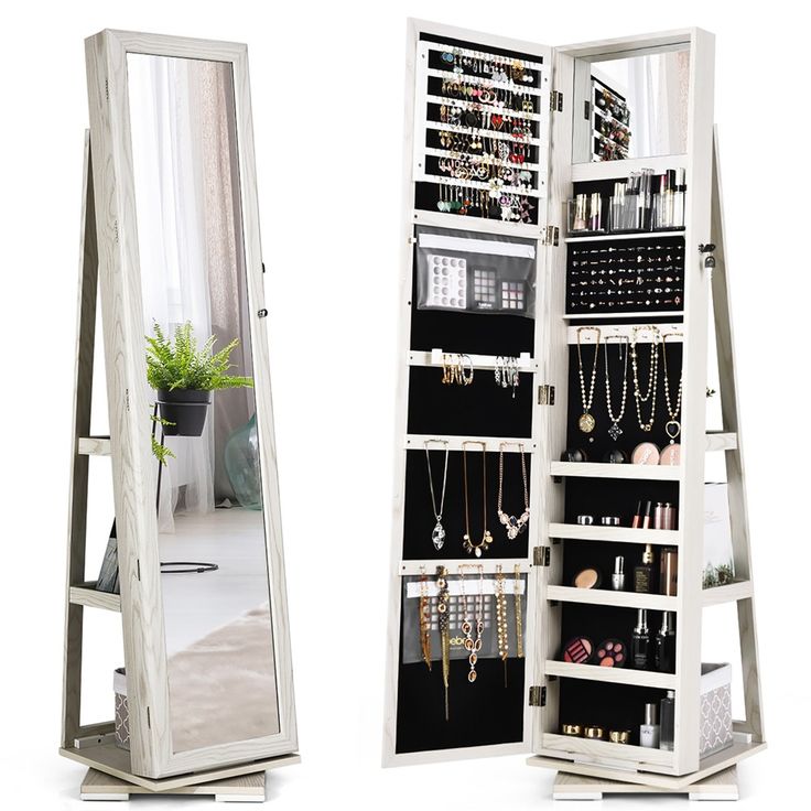 a white jewelry cabinet sitting next to a mirror