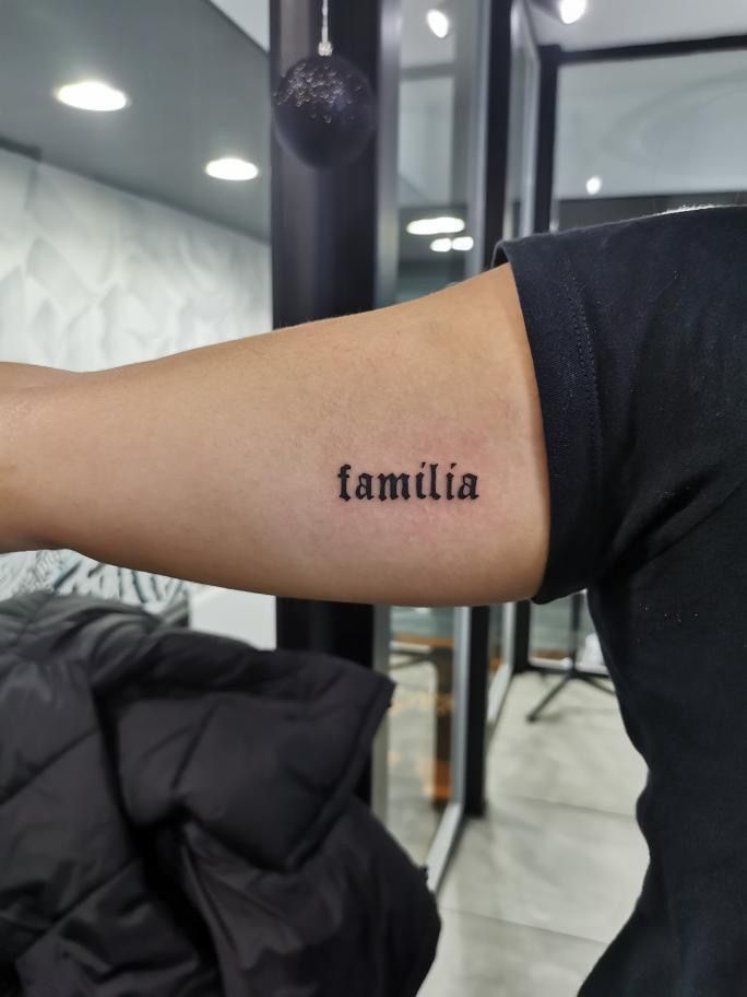 a woman's arm with the word familia tattooed on it