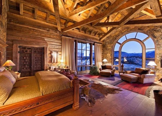 a large bedroom with an arched window overlooking the city and mountains is pictured in this image