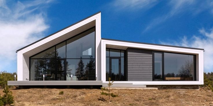 a modern house sits on top of a hill